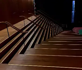 Einbauleuchte Holzstufen Einbauleuchten mit warmweißem Licht in Holzstufen. Stufenkanten sind durch das Leuchten erkennbar in dem abgedunkelten Raum