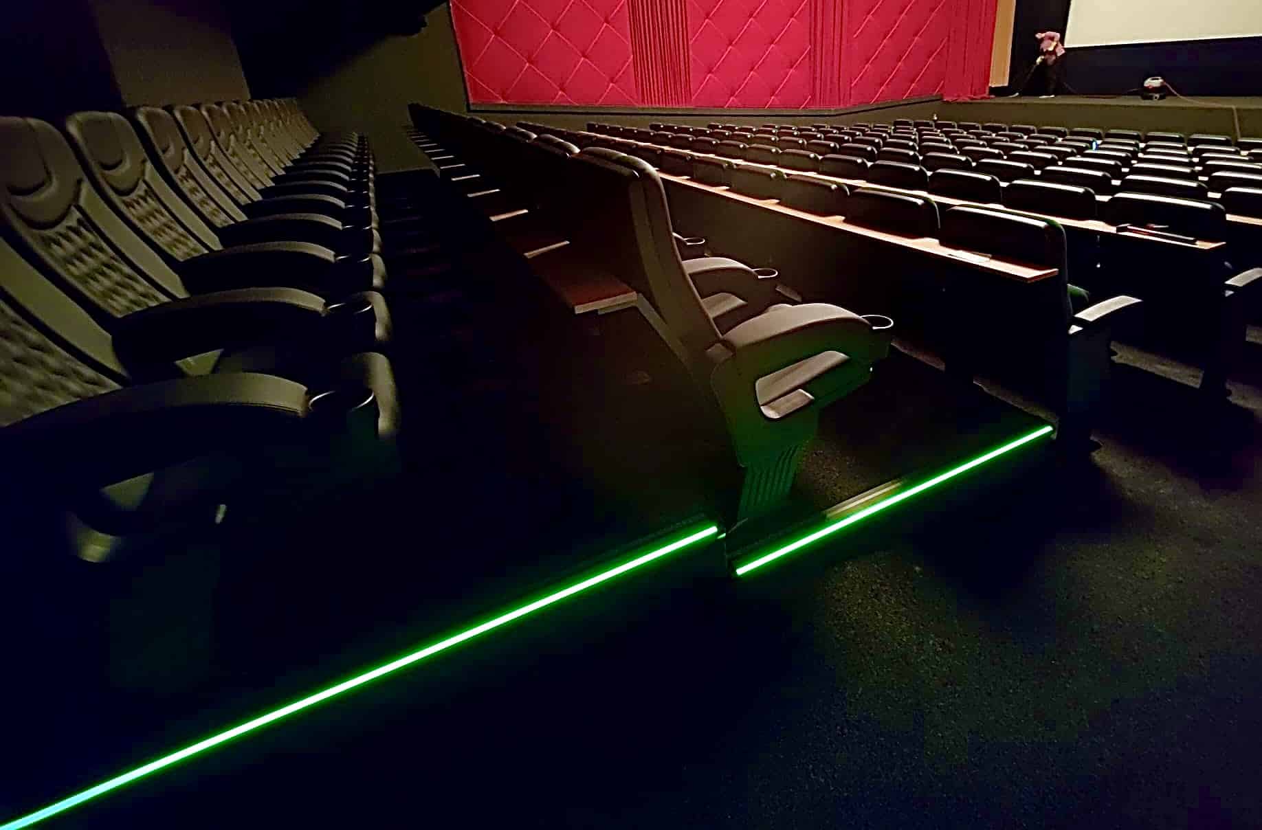 Kinosaal mit grün beleuchteten Stufenkanten
