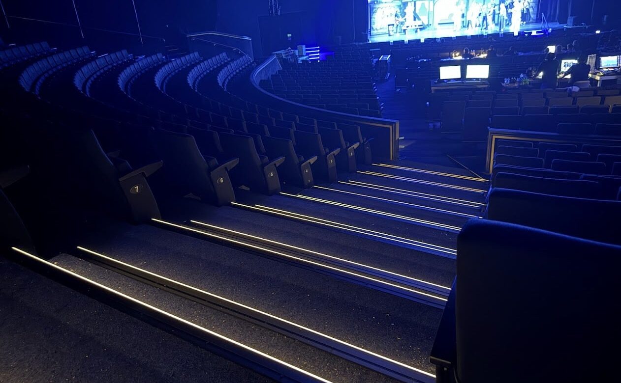 Stufenkantenprofile-mit-LED-im-Theatersaal warm weiß leuchtende Stufenkantenprofile während einer Show