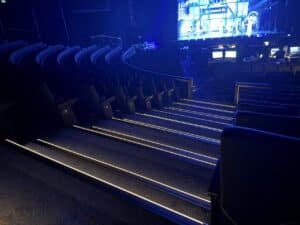 Stufenkantenprofile-mit-LED-im-Theatersaal warm weiß leuchtende Stufenkantenprofile während einer Show